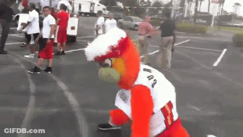 A Mascot Wearing A White Shirt With The Number 83 On It Stands In A Parking Lot GIF