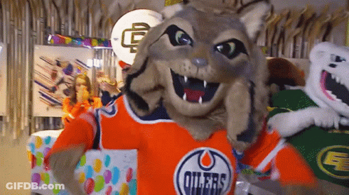 A Mascot Wearing An Oilers Jersey Holds A Gift Box GIF