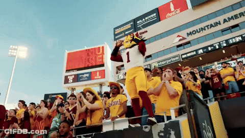 A Mascot Wearing Number 1 Stands In Front Of A Crowd Of People GIF