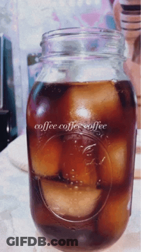 A Mason Jar Filled With Ice Cubes And The Words Coffee Coffee Coffee On It GIF