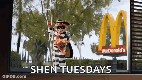 A Mcdonald 'S Advertisement With A Doll Dressed As A Prisoner Holding A Pizza GIF