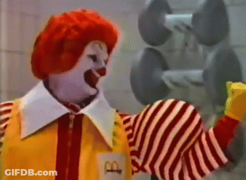 A Mcdonald 'S Clown Is Holding A Dumbbell In His Hand GIF