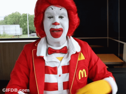 A Mcdonald 'S Clown Wearing A Red And White Striped Shirt GIF