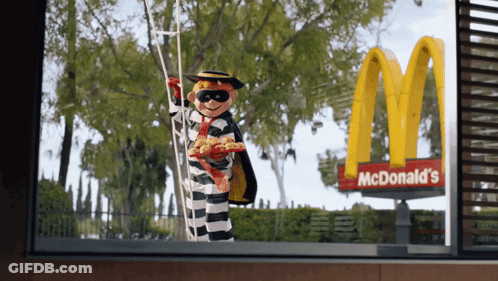 A Mcdonald 'S Sign With A Prisoner Holding A Ladder GIF