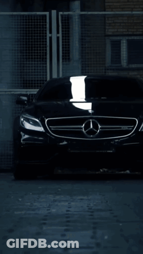 A Mercedes Car Is Driving Down A Wet Road At Night GIF