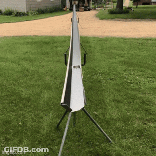 A Metal Pipe Is Sitting In The Middle Of A Grassy Field GIF