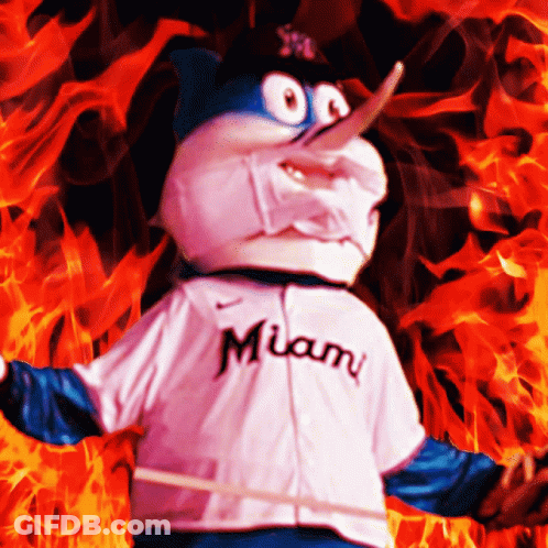 A Miami Mascot Is Standing In Front Of A Fire GIF