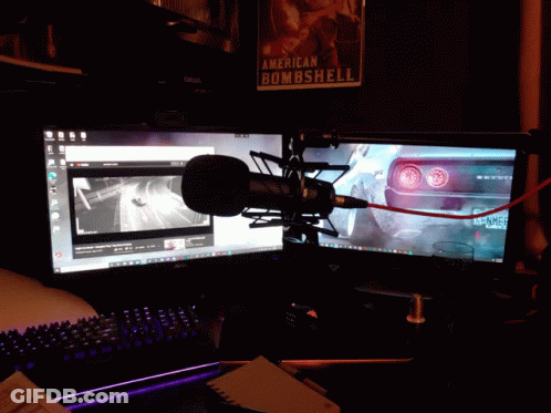 A Microphone Is Sitting In Front Of Two Computer Monitors And A Poster That Says American Bombshell GIF