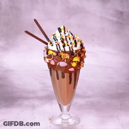 A Milkshake With M & M 'S And Oreos On Top Of It GIF