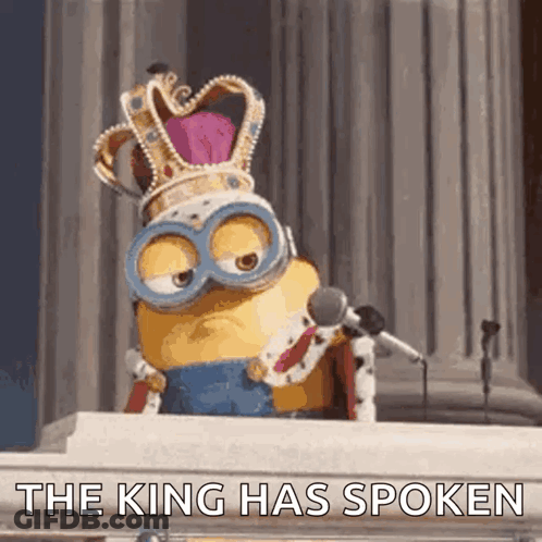 A Minion Wearing A Crown And Goggles Is Speaking Into A Microphone And Says " The King Has Spoken " GIF