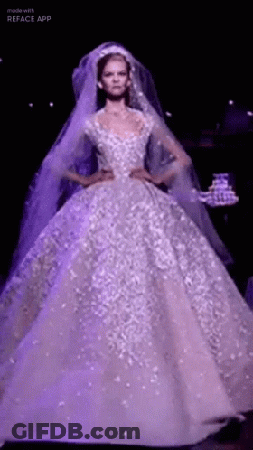 A Model Is Walking Down The Runway Wearing A Purple Wedding Dress . GIF