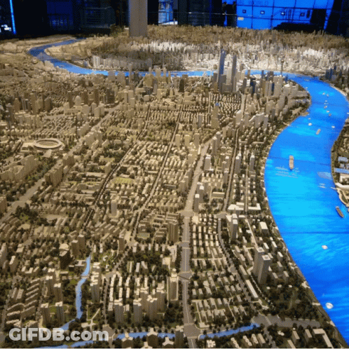A Model Of A City With A River And A Lot Of Buildings GIF
