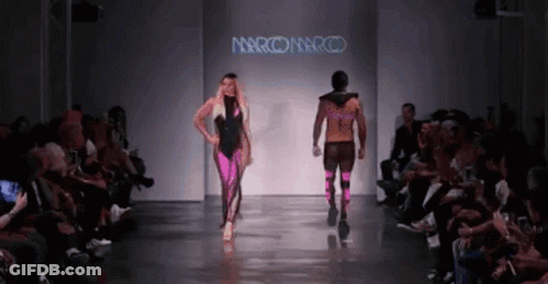 A Model Walks Down A Runway At A Fashion Show Sponsored By Marco Marco GIF