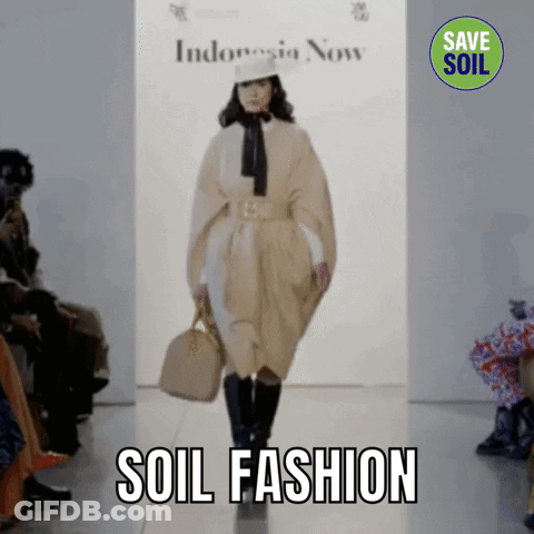 A Model Walks Down A Runway At A Fashion Show With The Words Soil Fashion Behind Her GIF