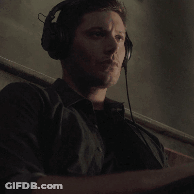 A Monkey Is Wearing Headphones And Holding A Microphone In Its Hand . GIF