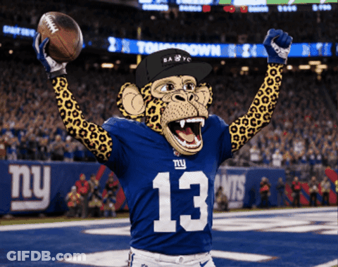 A Monkey Wearing A Ny Giants Jersey Holds A Football In His Hands GIF