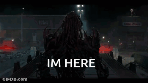A Monster Is Standing In A Dark Room With The Words Im Here Written On The Bottom . GIF