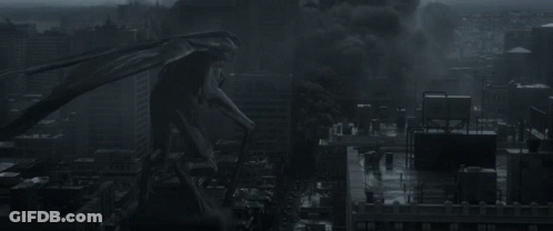 A Monster Is Standing In The Middle Of A City With Smoke Coming Out Of It 'S Mouth GIF
