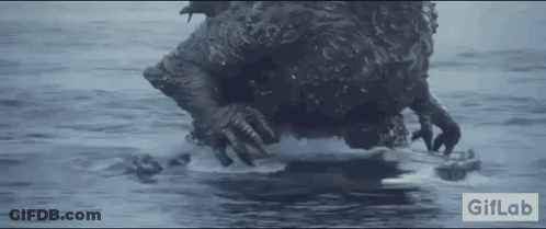 A Monster Is Swimming In The Ocean With A Remote Control In Its Mouth . GIF