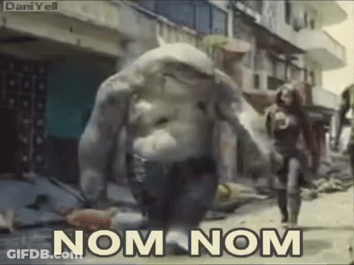 A Monster Is Walking Down A Street With The Words Nom Nom Written On The Bottom GIF