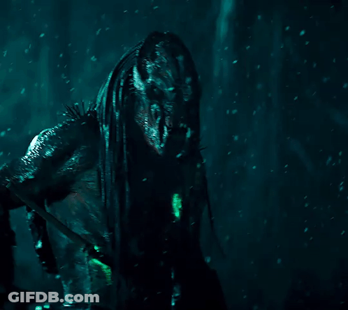 A Monster With Dreadlocks And Sharp Teeth Stands In The Dark GIF