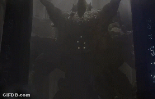 A Monster With Horns Is Standing In A Dark Forest GIF