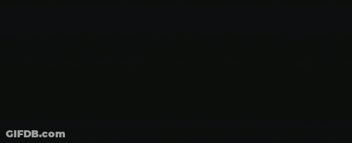 A Monster With Large Teeth Is Standing In The Dark GIF