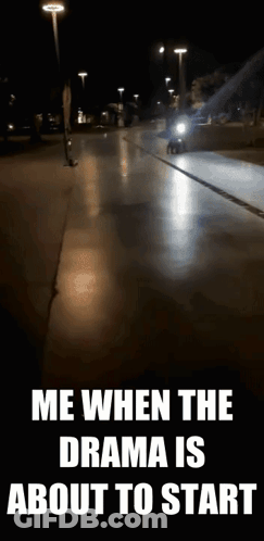 A Motorcycle Is Driving Down A Street At Night With A Caption That Says Me When The Drama Is About To Start . GIF