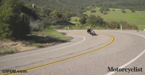 A Motorcycle Is Going Down A Curvy Road With The Words Motorcyclist Below It GIF