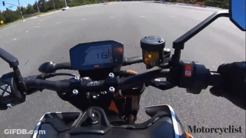 A Motorcyclist Is Riding A Ktm Motorcycle Down The Road GIF