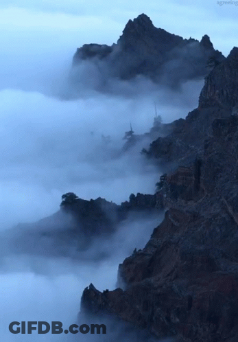 A Mountain Covered In Clouds With The Word Greeting Visible In The Corner GIF