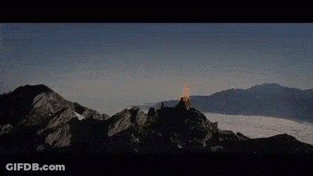 A Mountain Covered In Snow With A Few Clouds In The Sky GIF
