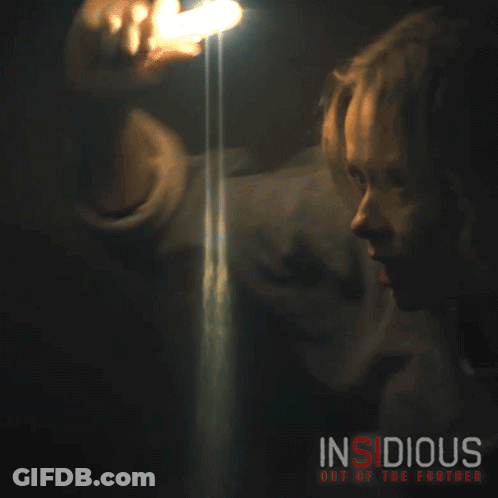 A Movie Poster For Insidious Out Of The Further Shows A Woman Holding A Flashlight GIF
