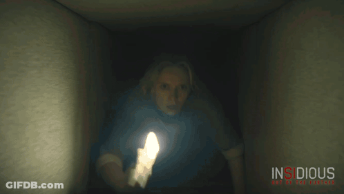 A Movie Poster For Insidious Shows A Woman Holding A Flashlight In A Dark Room GIF