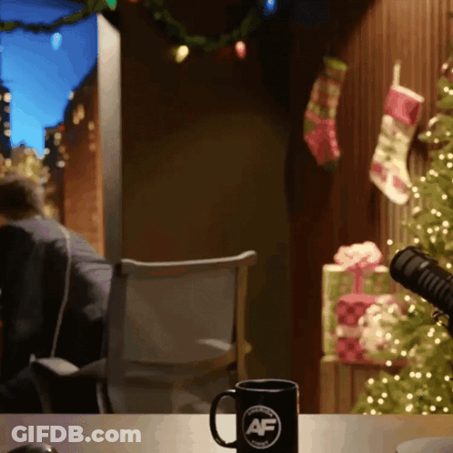 A Mug With The Letter Af On It Sits On A Table In Front Of A Christmas Tree GIF