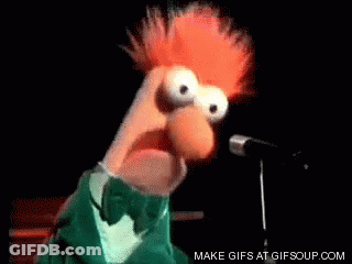 A Muppet Is Singing Into A Microphone While Wearing A Green Tuxedo And Bow Tie . GIF
