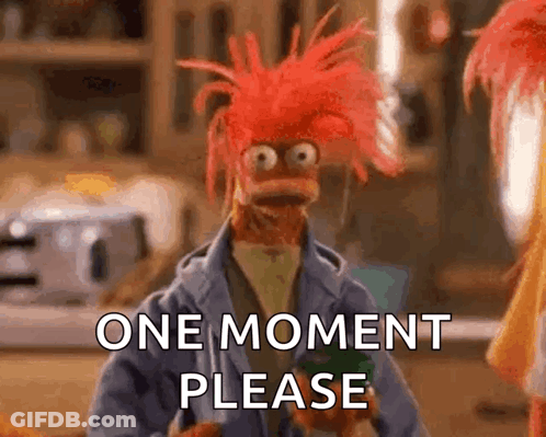 A Muppet With Red Hair Is Asking For A Moment Please GIF