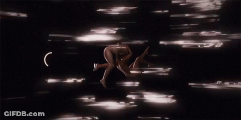 A Naked Man Is Being Held Up By Another Man In A Dark Room GIF