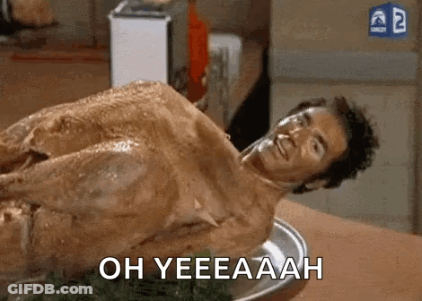 A Naked Man Is Laying On Top Of A Turkey On A Table . GIF