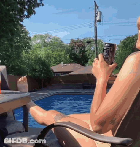 A Naked Man Is Sitting In A Chair Holding A Can Of Coke GIF