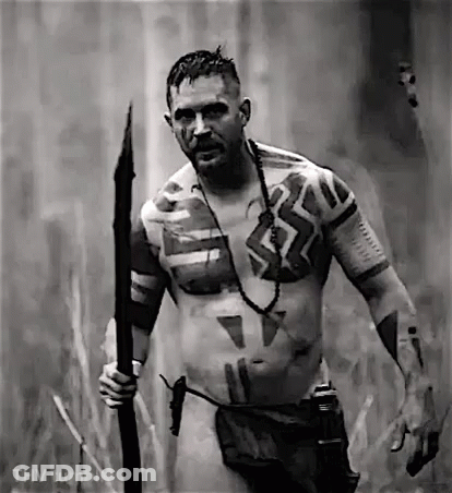 A Naked Man With Tattoos On His Body Is Holding A Spear . GIF