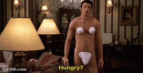 A Naked Man With Whipped Cream On His Chest Is Standing In A Living Room Asking If He Is Hungry GIF