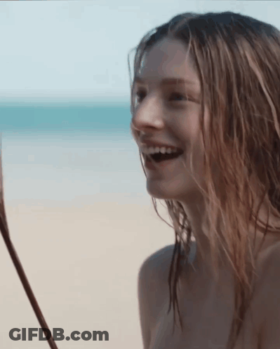 A Naked Woman Is Laughing On The Beach GIF