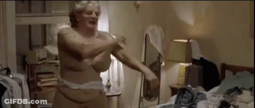 A Naked Woman Is Standing In A Messy Room With A Mirror . GIF