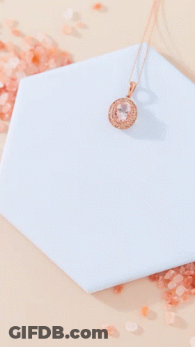 A Necklace Is Sitting On A Blue Tile Next To A Pile Of Salt GIF