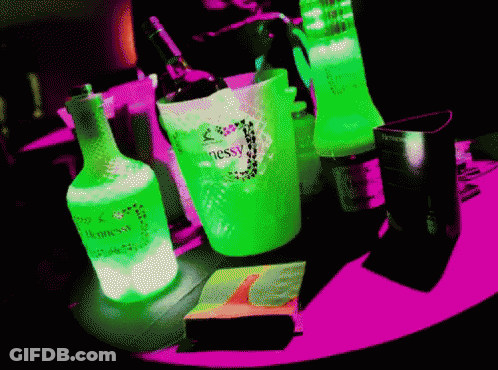 A Neon Green Bottle Of Hennessy Sits On A Pink Table GIF
