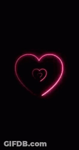 A Neon Heart Is Glowing In The Dark On A Black Background GIF