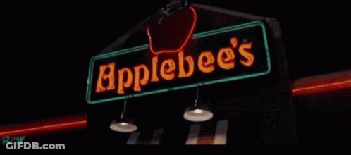 A Neon Sign For Apple 'S Bar Is Lit Up In The Dark GIF
