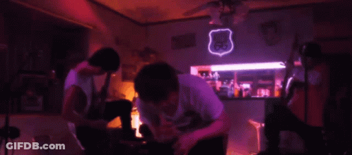 A Neon Sign For Route 66 Hangs From The Ceiling In A Dark Room GIF