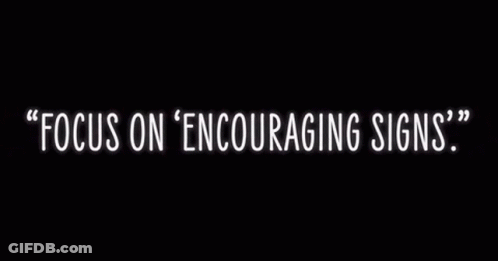 A Neon Sign That Says Focus On Encouraging Signs On A Black Background GIF